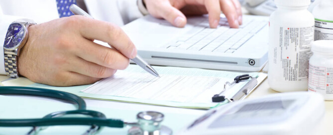doctor writing at his desk