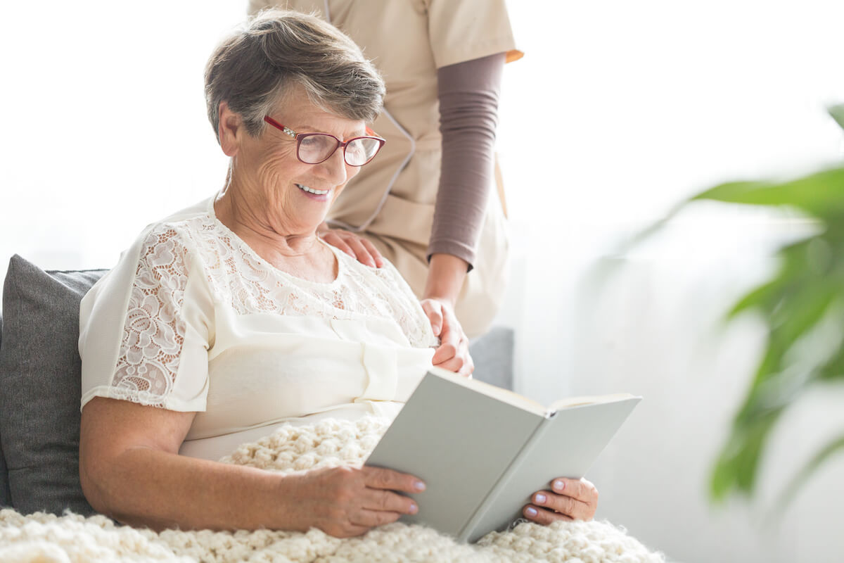 older woman reading a book smiling