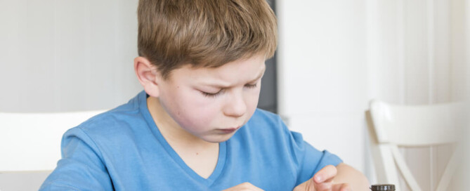 young boy checking glucose levels