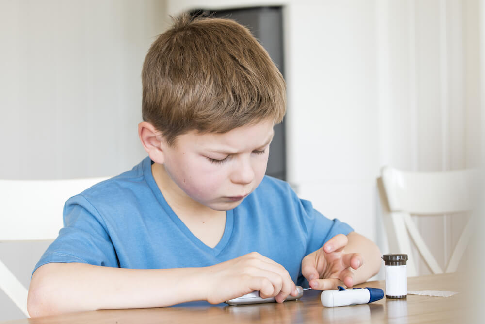 young boy checking glucose levels